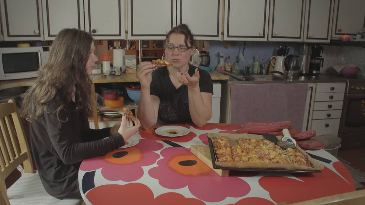 Suomen vahvin nainen 2018 Annika Eilmann ja hänen tyttärensä Emilia syövät pizzaa keittiössä kotonaan Pöytyällä.