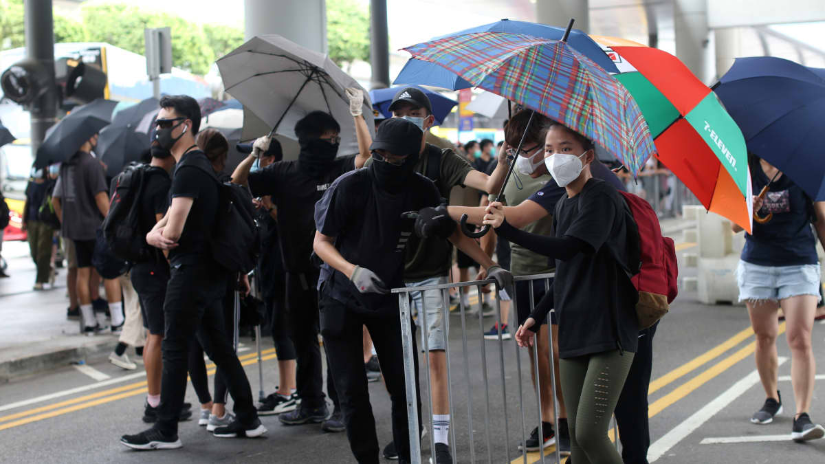 Kuvan mielenosoittajat ovat kokoontuneet Hongkongin lentokentälle. Protestoijien tarkoitus on häiritä kaupungin lentoliikennettä.