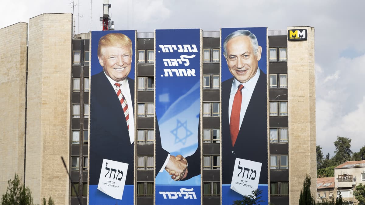Bibi ja Trump kättelevät suuressa kerrostalon päätyyn pystytetyssä jusiteessa. 