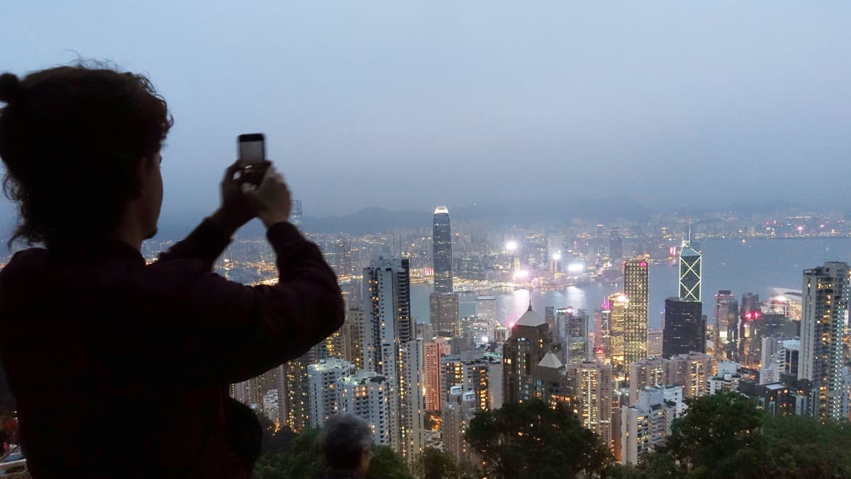 Turisti kuvaa näkymän Hongkongin keskusta Victoria Peakin huipulta.