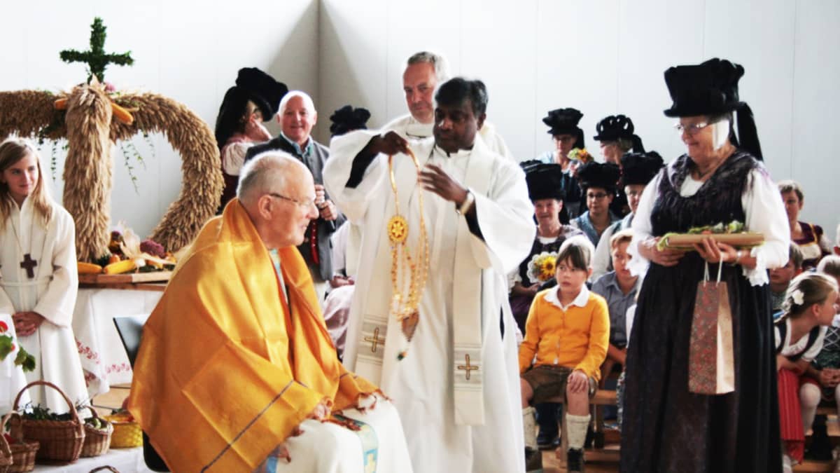 Glaneggin pappi Francis Nelaturi on kotoisin Intiasta. Hän suoritti itävaltalaisen sadonkorjuumessun päätteeksi intialaisen kiitosseremonian vieraana olleelle papille.