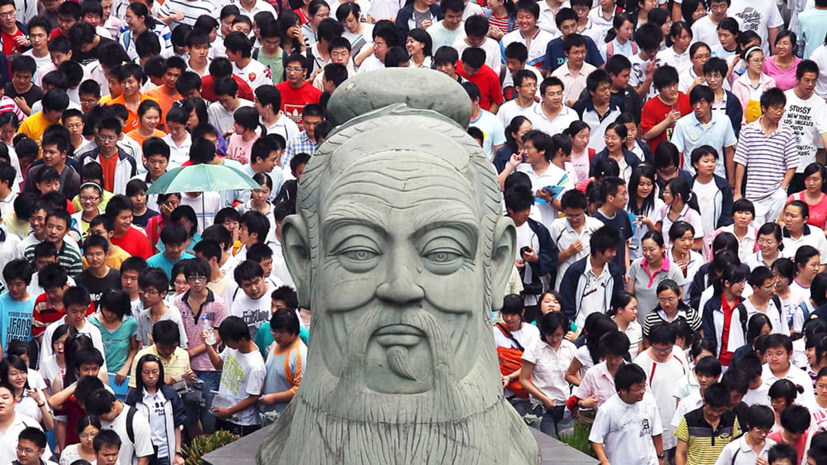 Opiskelijat ympäröivät Kungfutsen patsaan Wuhanissa.