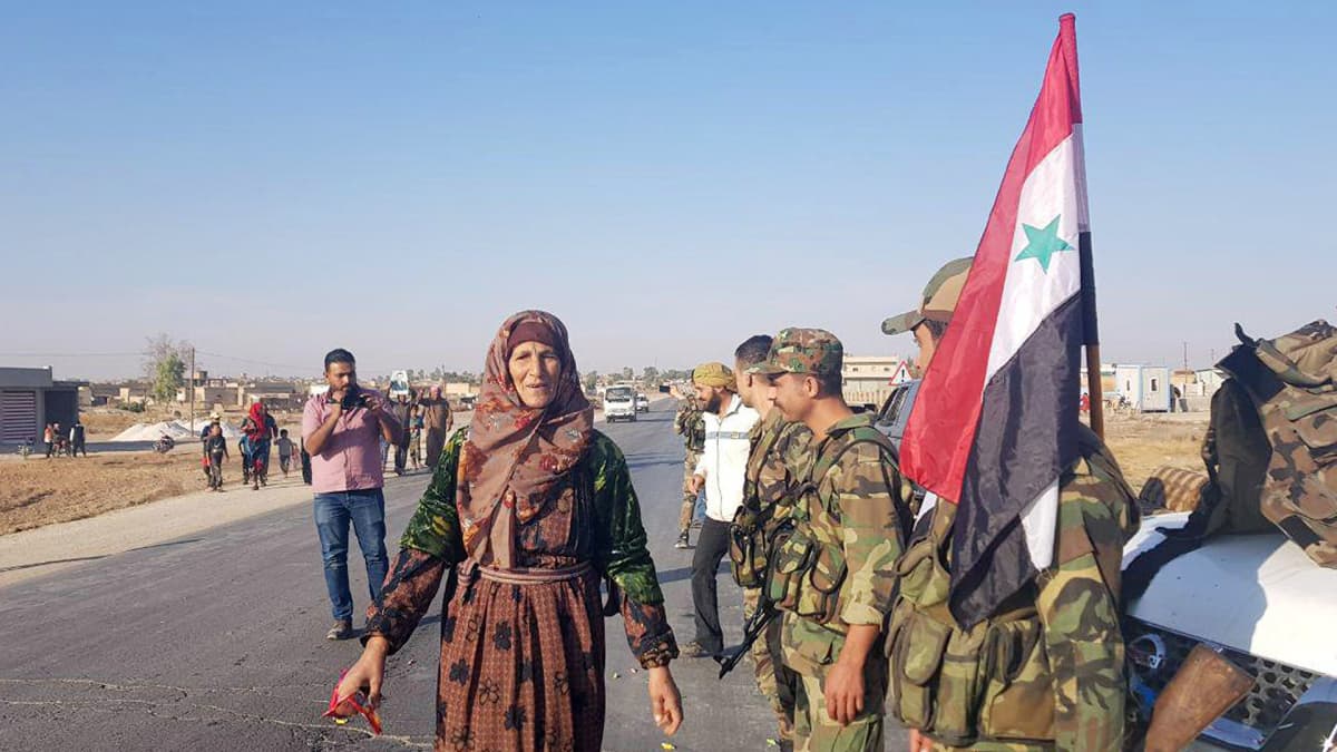 Siviilit tervehtivät Syyrian hallinnon joukkoja Tal Tamr -kaupungissa 14.10.
