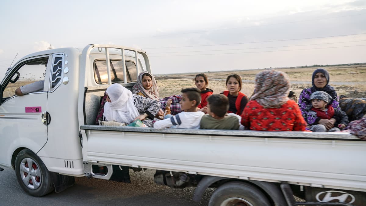 Pakolaisia avolavakuorma-autossa.