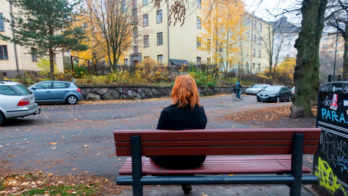 Nainen istuu penkillä Helsingissä.