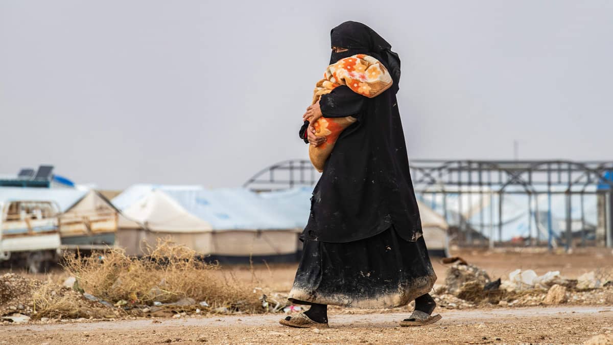 Nainen kantoi lasta al-Holin leirillä 9. joulukuuta.
