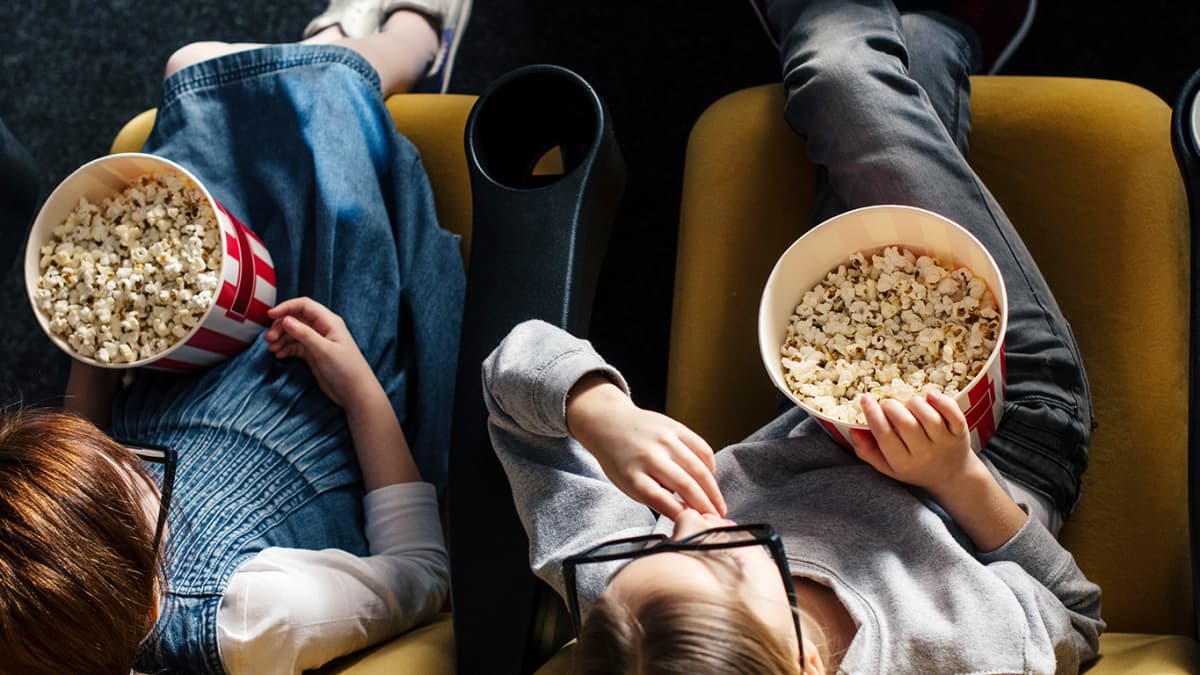 kaksi lasta katsoo elokuvaa teatterissa