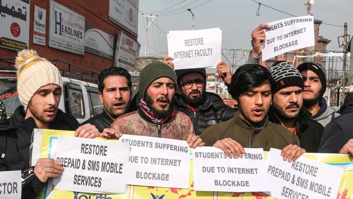 Kashmirilaiset nuoret pitävät kylttejä joissa kritisoidaan puhelin- ja internetpalveluiden katkaisemista.