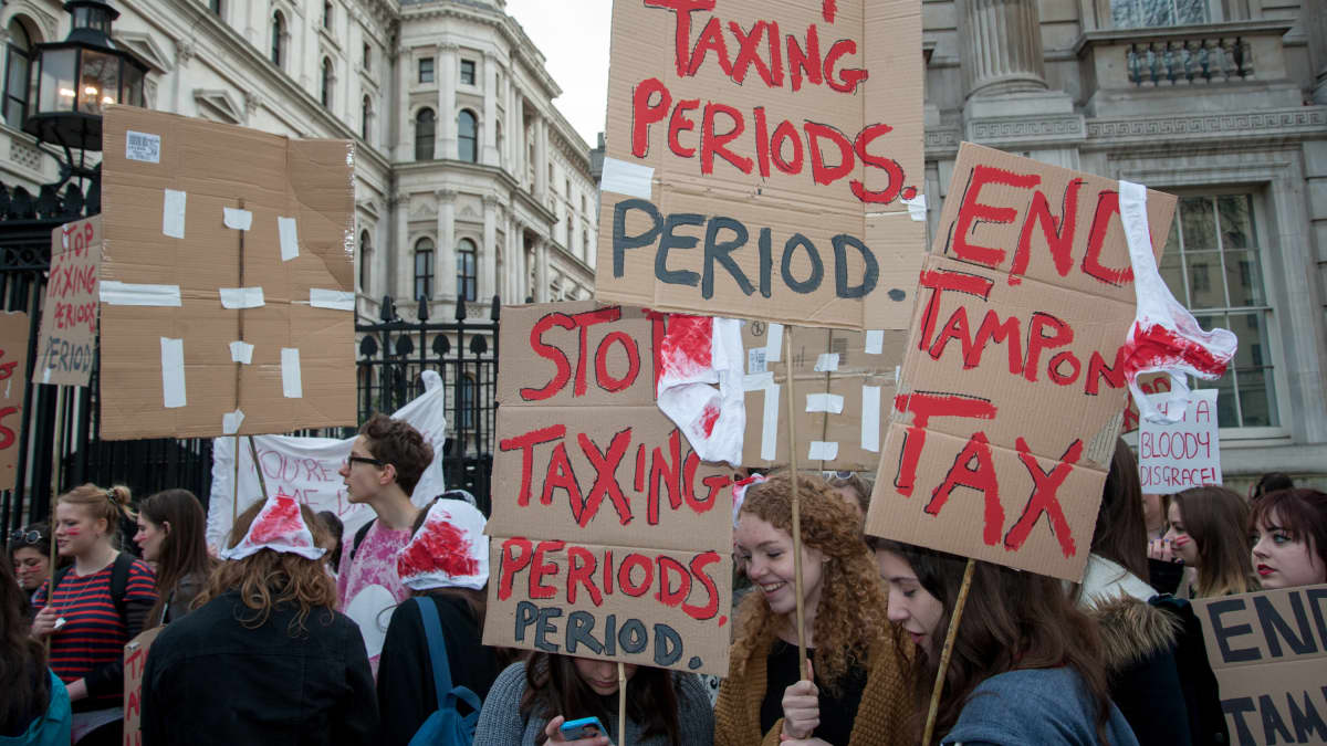 Naiset pitelevät kylttejä, joissa lukee muun muassa "Stop taxing periodes. Period."