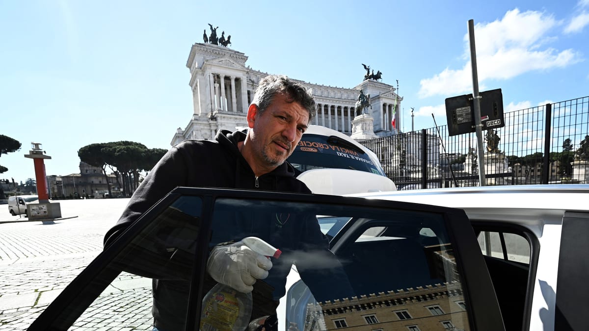 Taksikuski puhdistaa autoaan Roomassa.