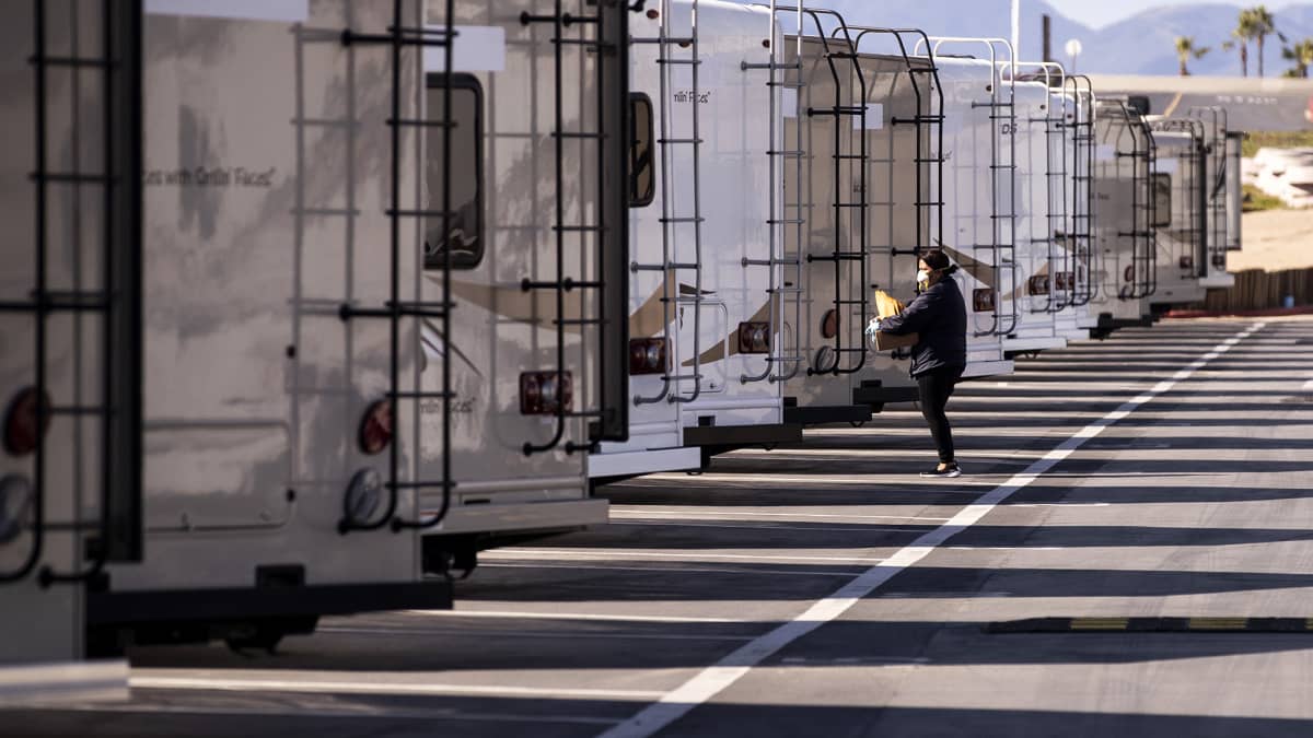 Terveysviraston työntekijä valmistelee asuntovaunuja karanteeniin määrättyjä varten Kaliforniassa.