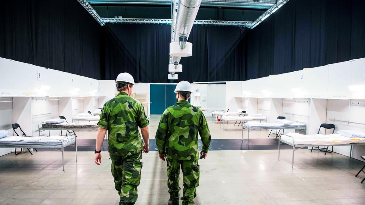 Ruotsin armeijan henkilökuntaa kävelee messukeskukseen rakenteilla olevassa kenttäsairaalassa Tukholmassa.