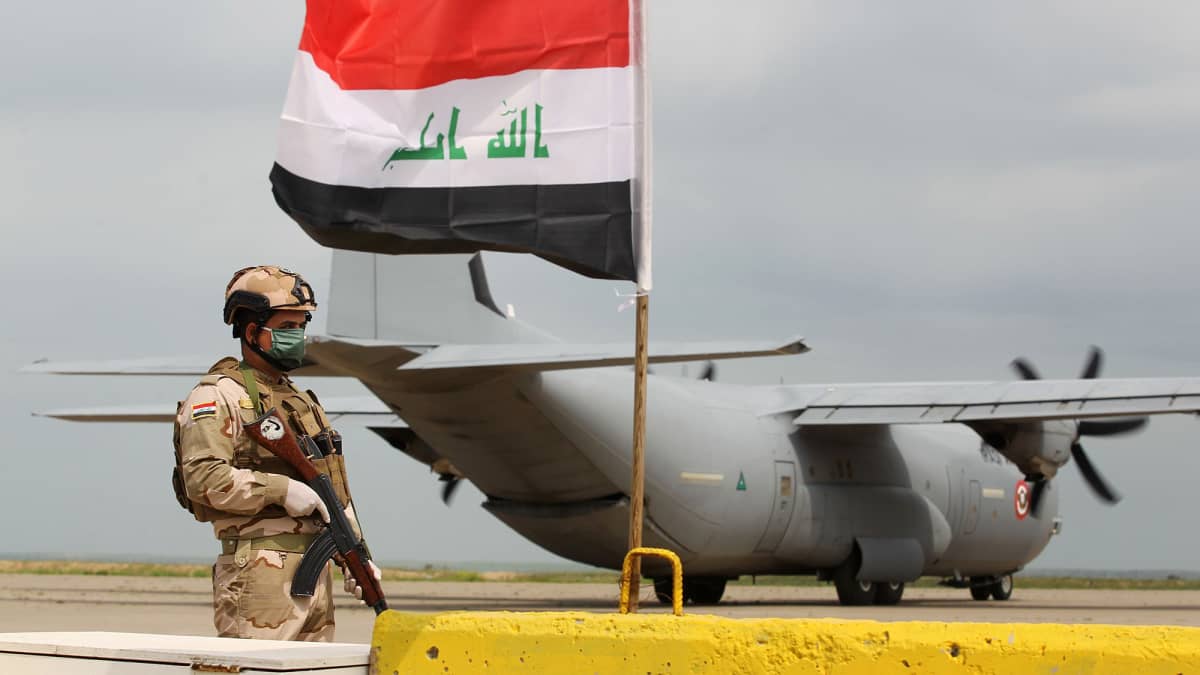 Sotilas seisoo Irakissa Yhdysvaltain lentokoneen edustalla.