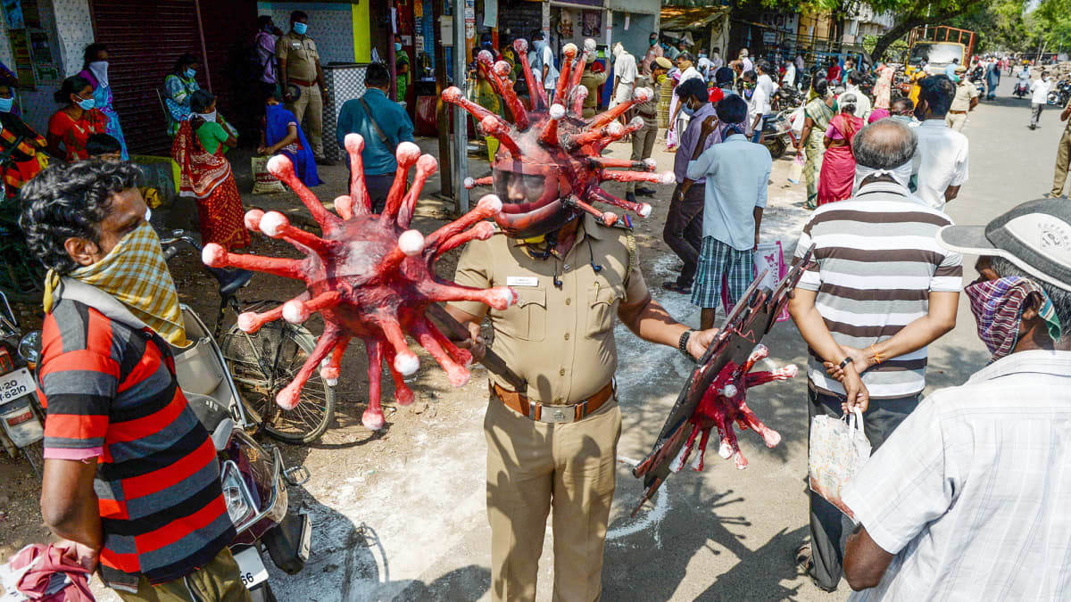 Intialainen poliisi pukeutuneena koronavirusta mallintavaan kypärään.