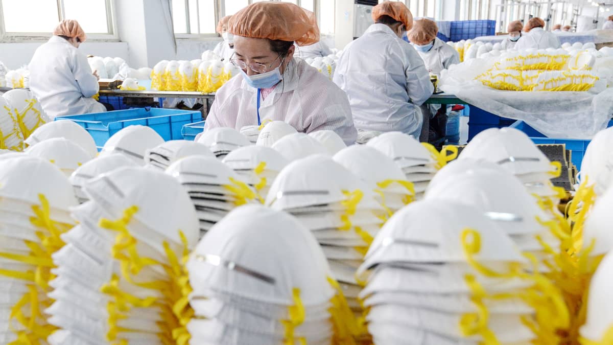 Työntekijät valmistavat hengityssuojaimia kiinalaisessa tehtaassa.