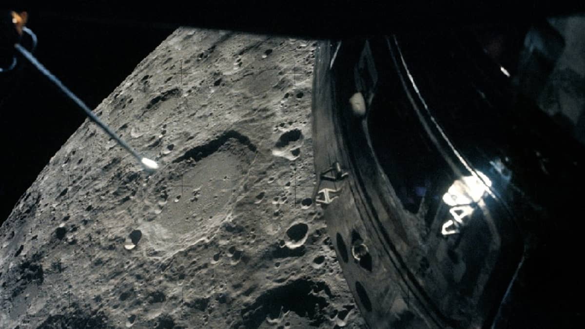 Kuun kraatterien täplittämää pintaa ja moduulin kylkeä ikkunasta katsottuna.