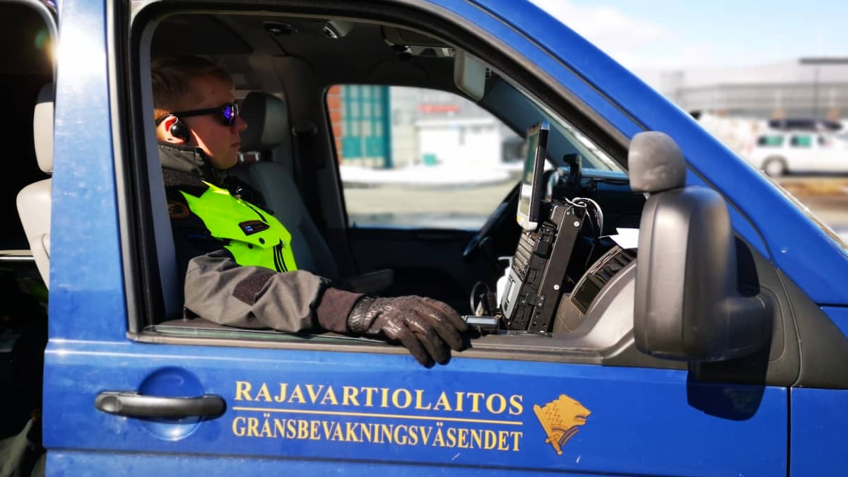 Rajavartija istuu autossa suorittamassa rajaliikenteen valvontaa.
