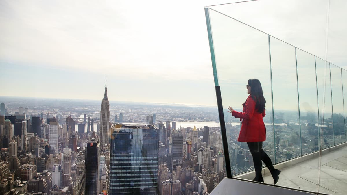 Nainen katsoo maisemaa pilvenpiirtäjän näköalatasanteella New Yorkissa.