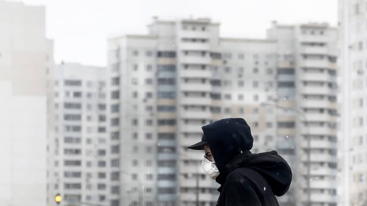 Mies suojautuneena hengitysuojaimeen kävelee Moskovassa.