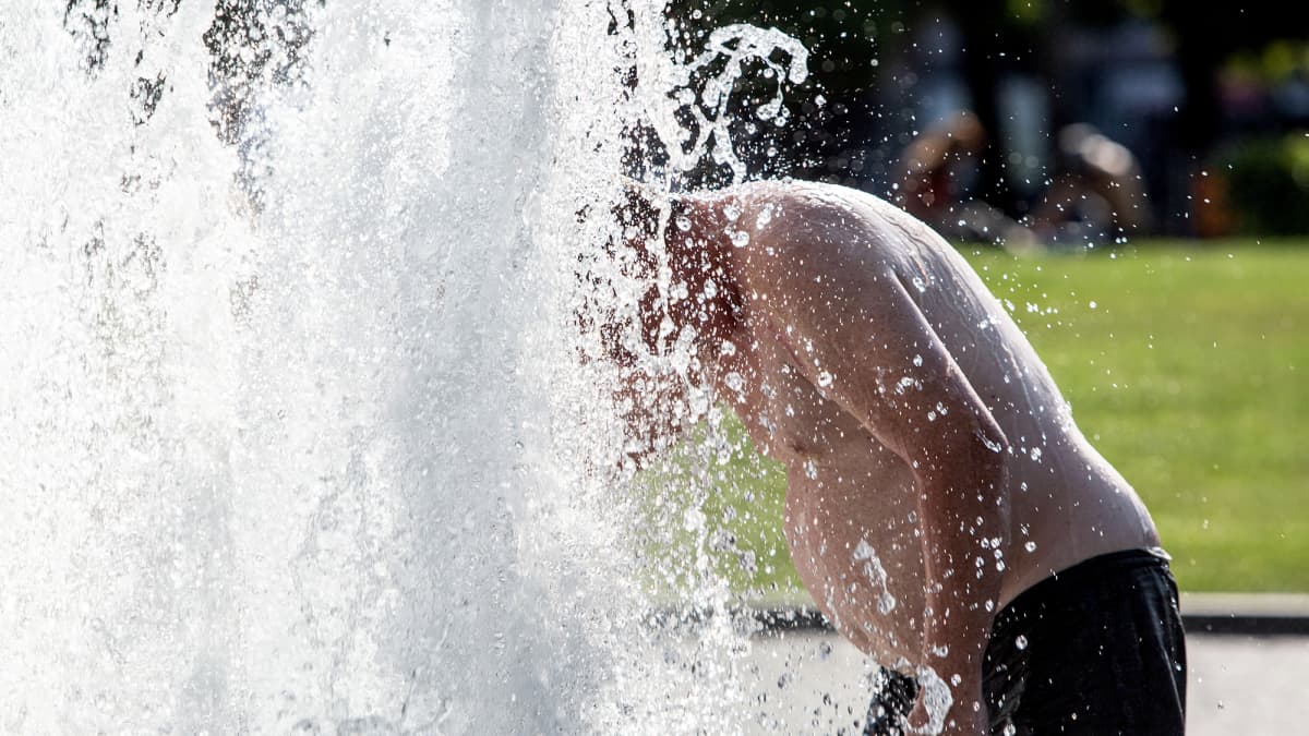 Mies vilvoittelee suihkulähteessä Berliinissä.