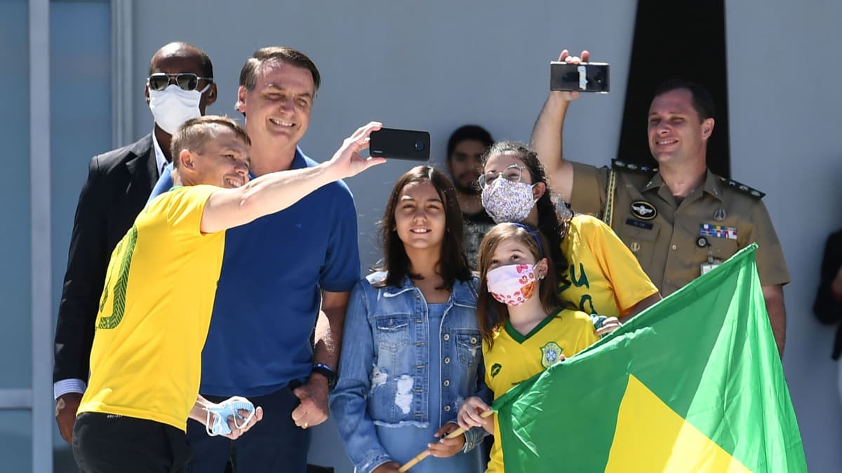 Jair Bolsonaro poseerasi selfiessä kannattajiensa kanssa Planalto-palatsin edustalla Brasiliassa sunnuntaina.