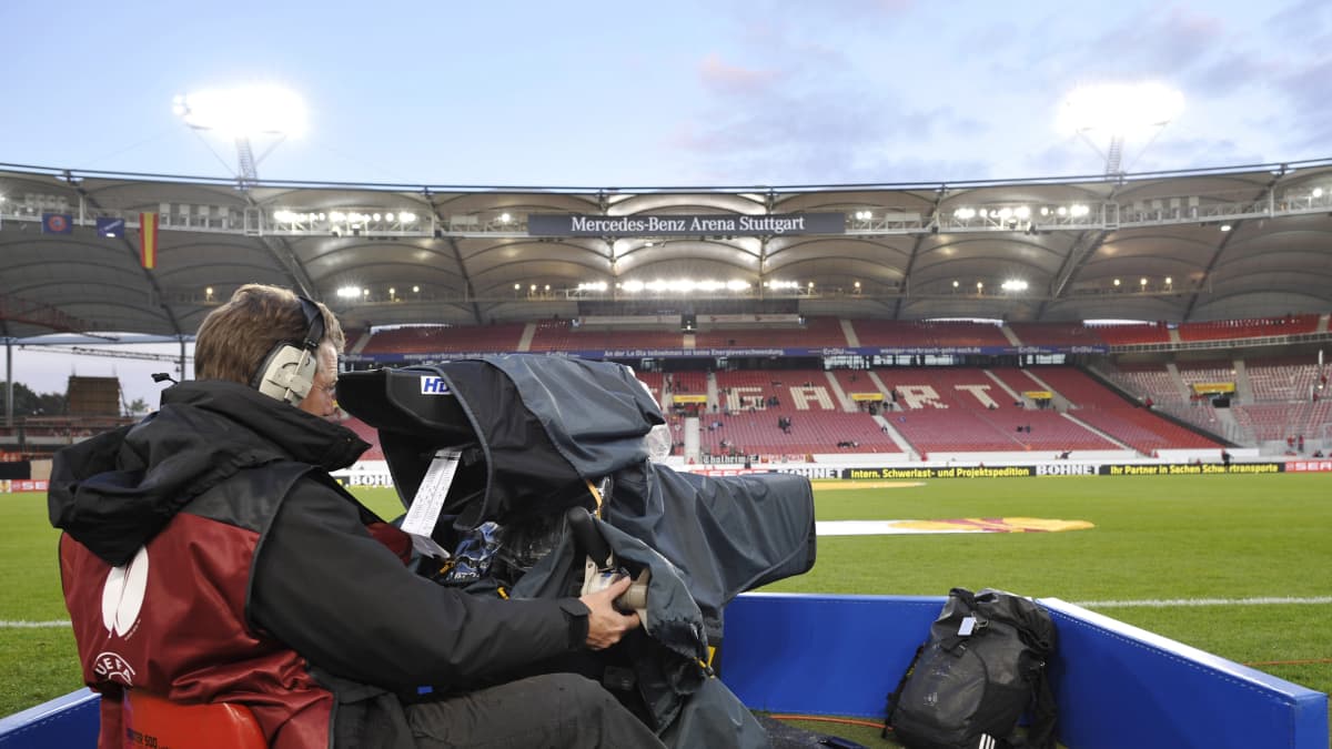 Tv-kameramies stadionilla valmiina kuvaamaan.