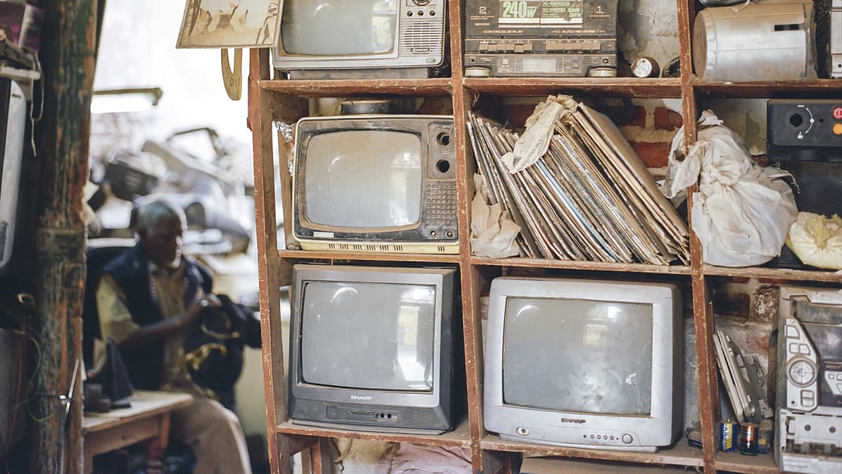 Kuvassa on vanhoja televisioita hyllyssä.