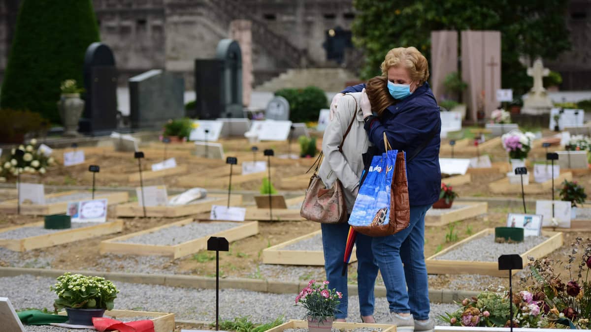 Kuvassa läheiset surevat haudalla Italiassa.