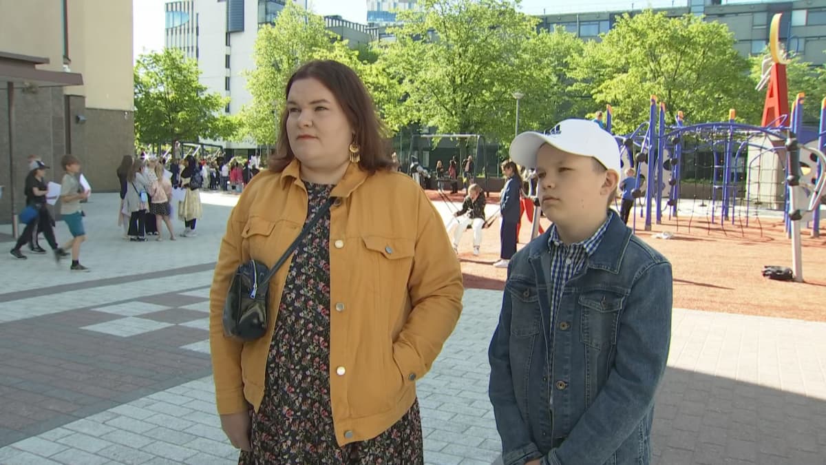 Viidennen luokan päättävä Topi Turunen ja hänen äitinsä Elina Turunen Ruoholahden alakoulun pihalla lauantaina.