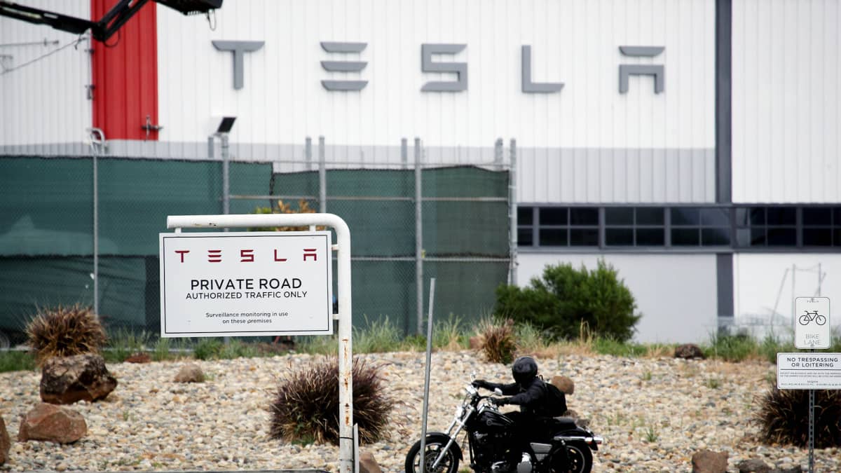 Moottoripyöräilijä Teslan tehtaan edustalla Kaliforniassa.