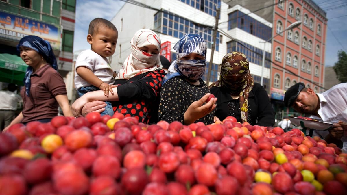Kuvassa uiguurinaisia hedelmätorilla Urumqin kaupungissa Xinjiangin maakunnassa Kiinassa. 