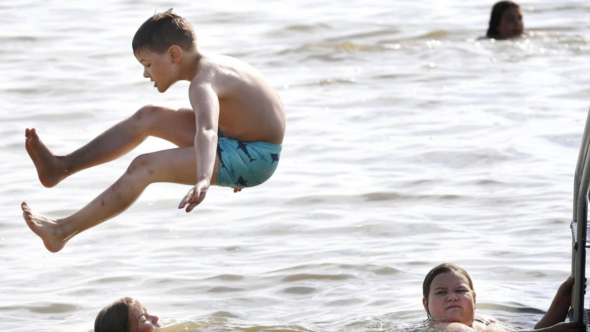 Kuvassa lapset uivat rannalla Järvenpäässä.