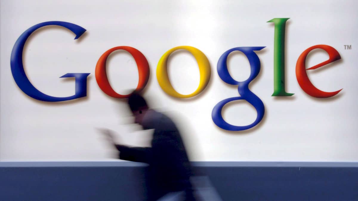 Mies kävelee Googlen logon editse