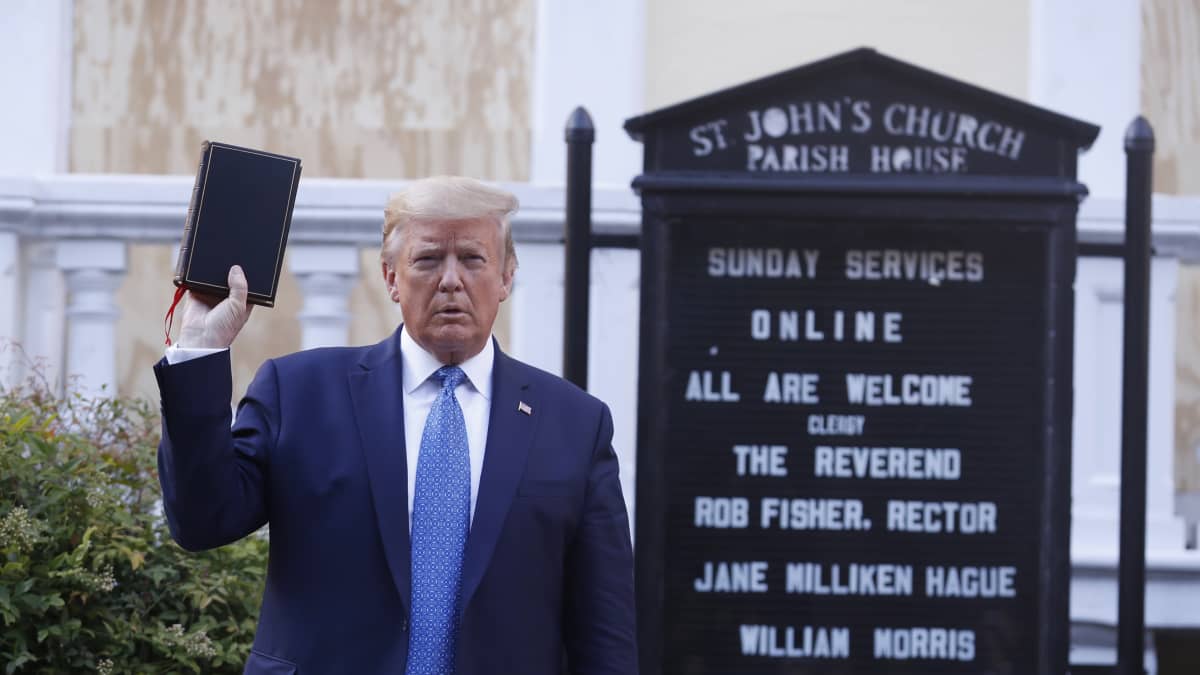 Presidentti Donald Trump poseeraa raamattu kädessään Valkoisen talon edustalla.