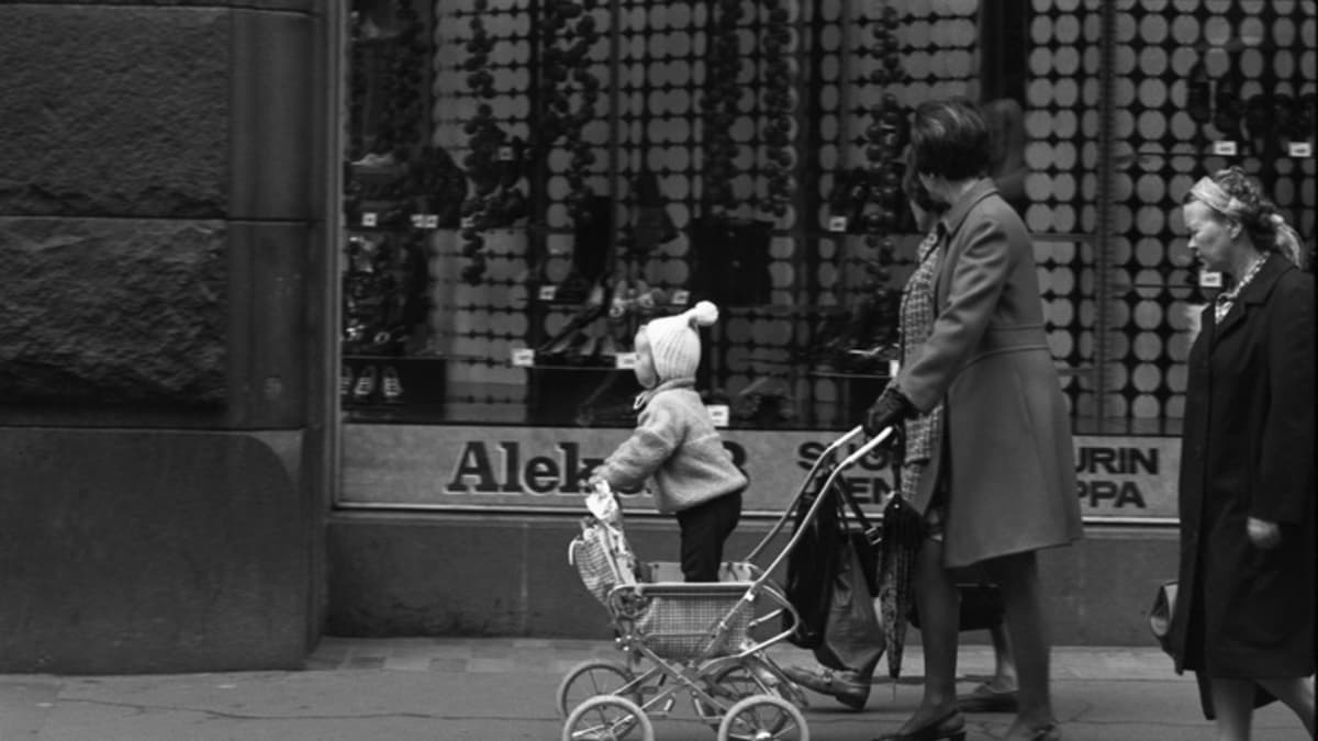 Aleksanterinkatu 13. Rattaissa seisovaa lasta työntävä nainen Aleksanterinkadulla kävelykatukokeilun aikaan vuonna 1970.