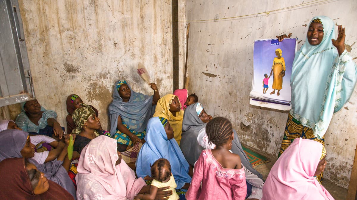 Perhesuunnittelun vapaaehtoisjäsen puhumassa naisille Kanossa, Nigeriassa.