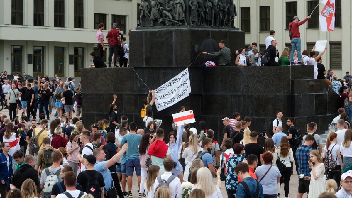 Ihmiset kiipesivät Minskin keskusaukiolla olevan Lenin-muistomerkin päälle.