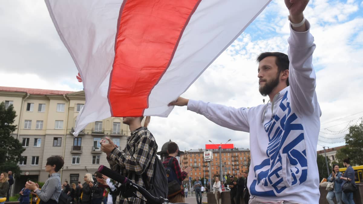 Mielenosoittaja liehutti Valko-Venäjän vanhaa lippua Minskissä torstaina.