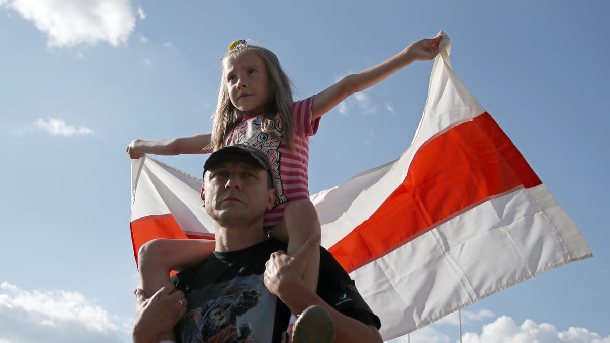 Lapsi piteli Valko-Venäjän vanhaa lippua lauantain mielenosoituksessa.