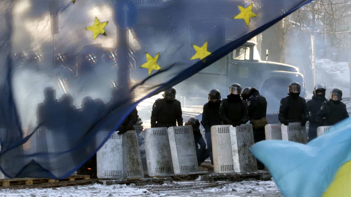 Ukrainan mellakkapoliiseja ja EU:n lippu edustalla