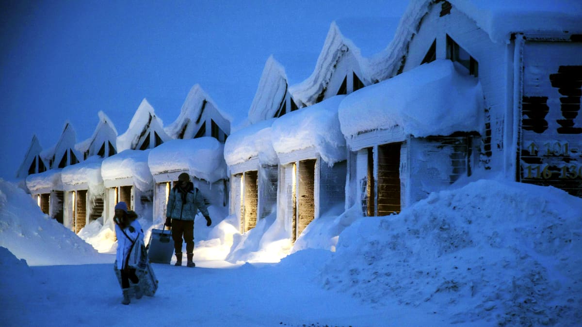 Turisteja lumisessa maisemassa Saariselällä.