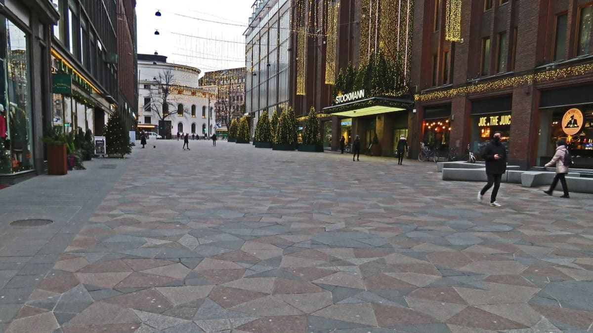 Laatoitettu kävlykatu. Oikealla Stockmannin tavaratalo, vasemmalla muita myymälöitä, kadun päässä Svenska Teatern.