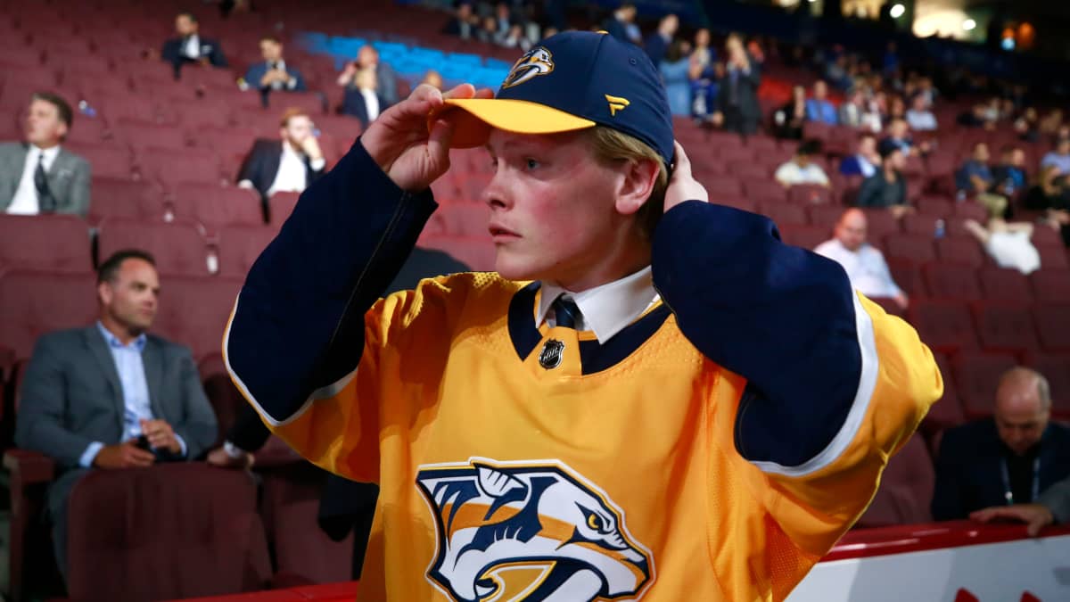 Juuso Pärssinen painaa Nashville Predatorsin lippiksen päähän NHL:n varaustilaisuudessa 2019.