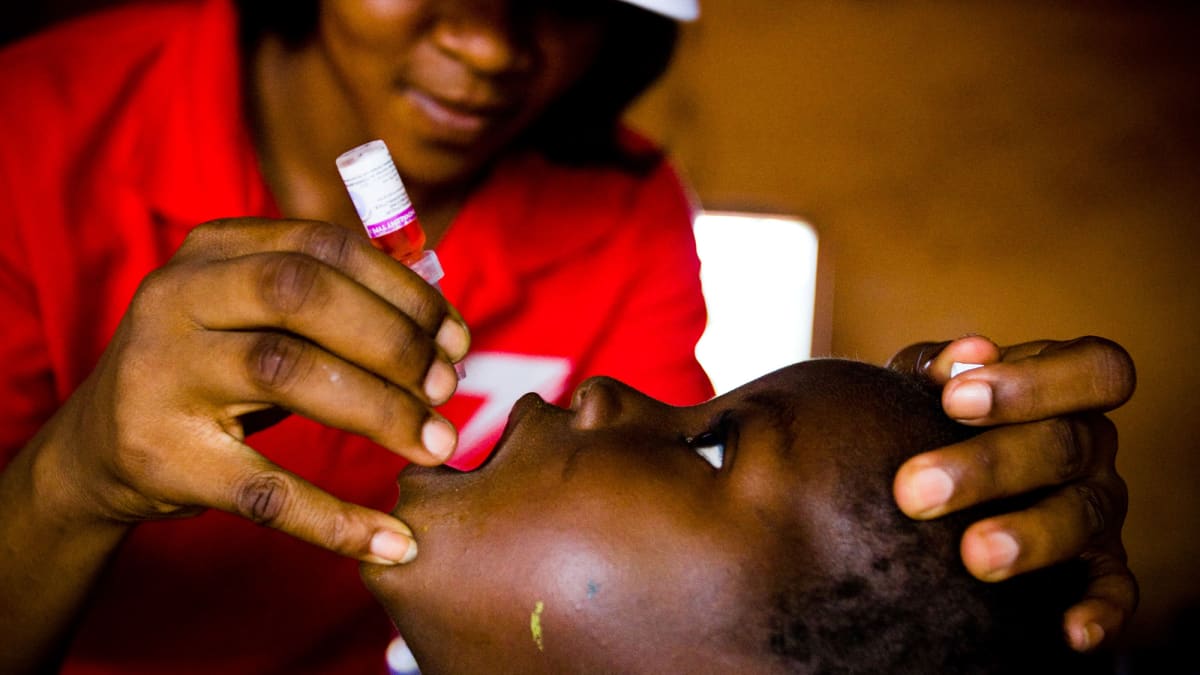 Sairaanhoitaja rokottaa lasta.