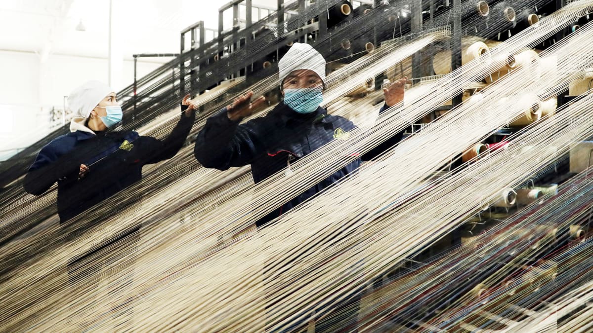 Työntekijöitä mattojen tuotantolinjalla Urumchissa, Xinjiangissa.
