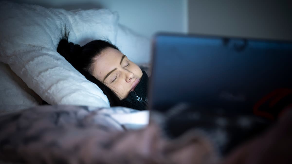 Theresa Laaksonen nukkuu tietokoneen näytön valossa