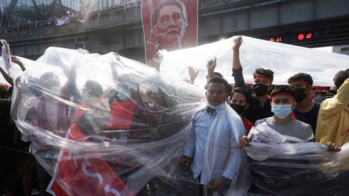 Mielenosoittajat suojautuvat muoveilla Yangonissa.