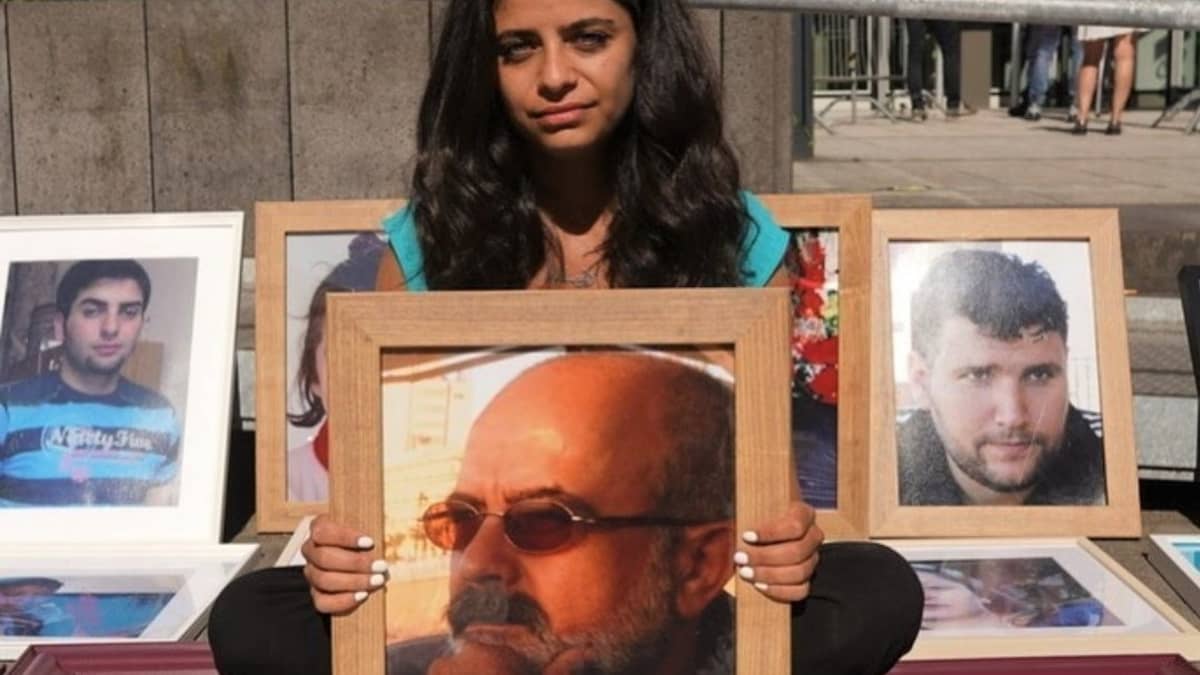 Syyrialaisnainen kädessään kuva kadonneesta isästään.
