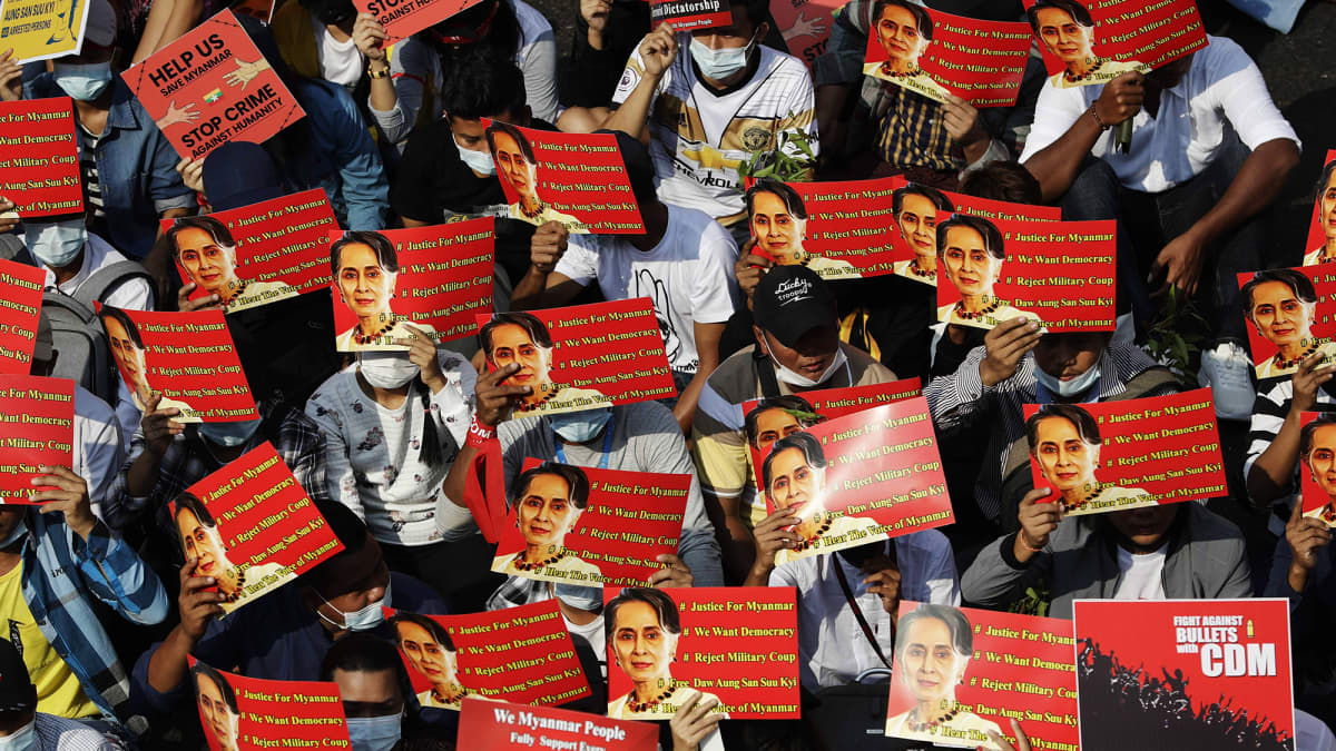Mielenosoittajat kannattelivat Myanmarin johdosta syrjäytyn Aung San Suu Kyin kuvaa Yangonissa.