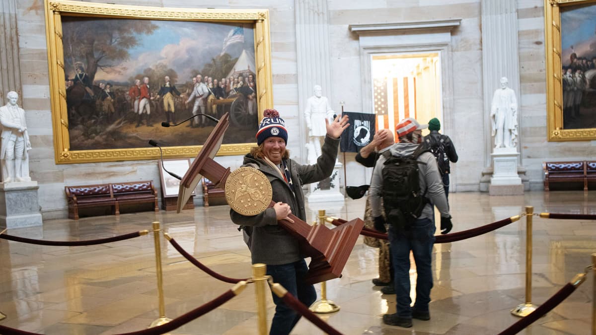 Mies kantaa Nancy Pelosin kongressitalon puhujapönttöä.